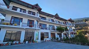 Multi-storey hillside hotel in Uttarakhand with balconies and mountain views, offering comfortable accommodation for travellers exploring Himalayan destinations like Munsiyari and Kumaon region.